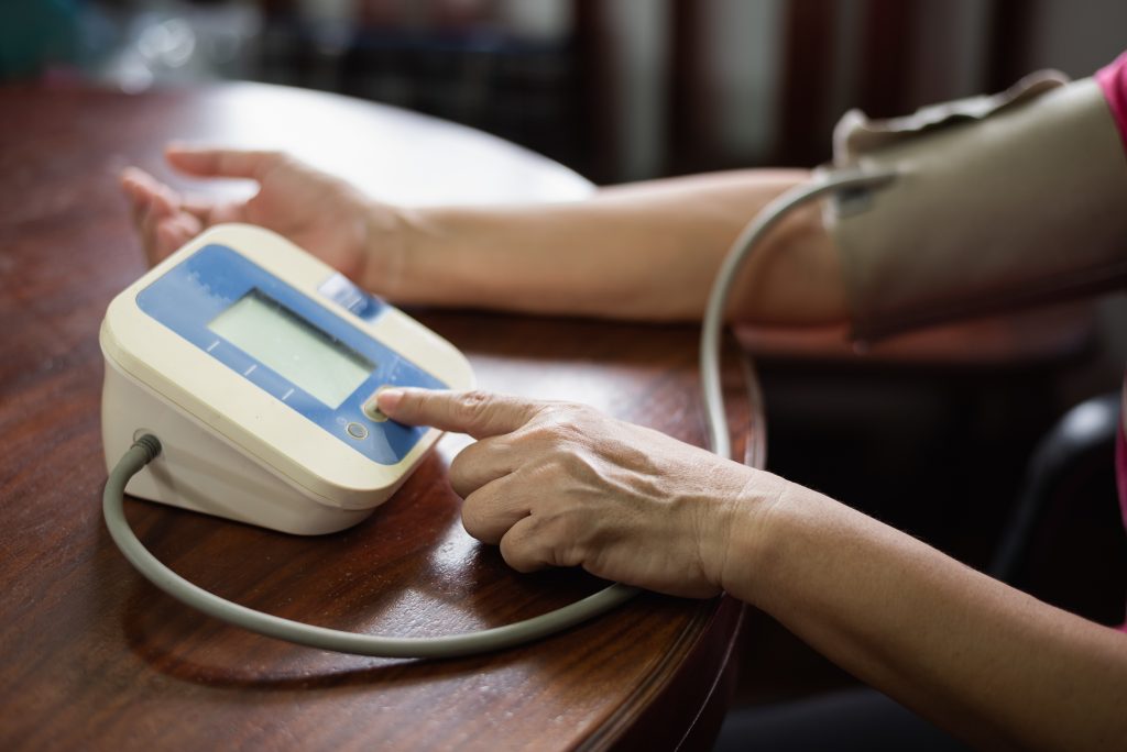 The woman takes care of her health by checking her blood pressure